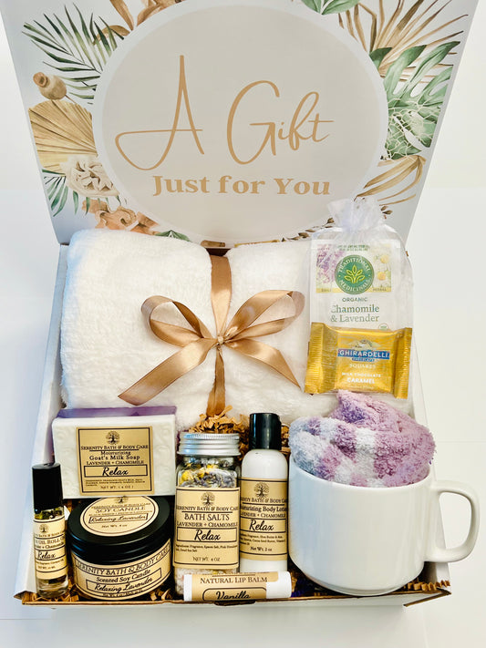Hygge Spa Gift Box for Women with blanket, lavender candle, soap, mug, fuzzy socks and comfort spa items arranged in a cozy gift basket.